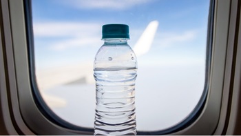Bottigli acqua vicino a finestrino aereo