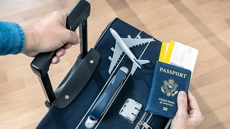 mano, passaporto e trolley