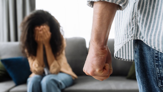 Donna vittima di violenza che piange sul divano