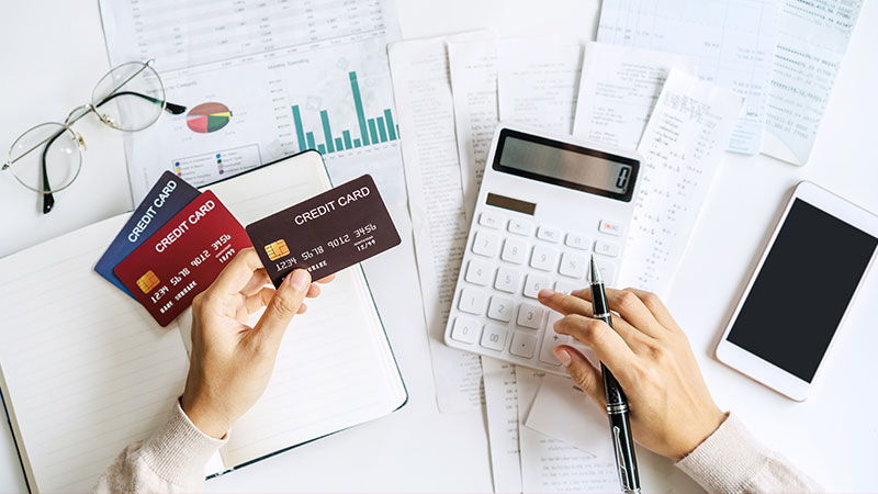 Mani con calcolatrice e carte di credito