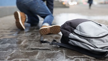 Persona cade a terra con zaino