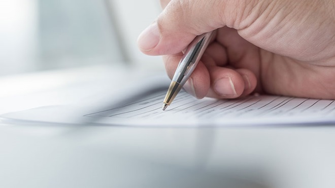 Mano firma con penna