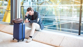 persona aspetta volo in ritardo