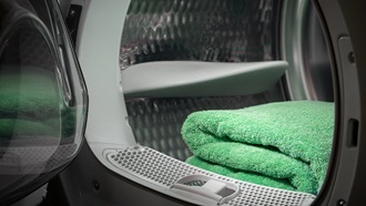 LAVASCIUGA APERTA CON DENTRO ASCIUGAMANO VERDE PRONTO PER ESSERE UTILIZZATO